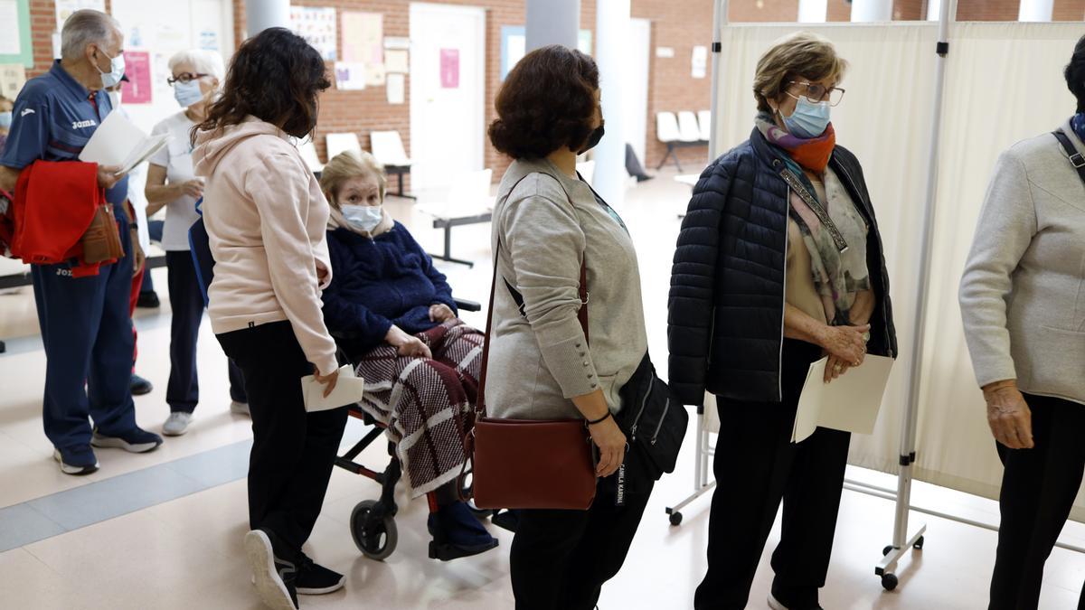 Varias personas esperan para vacunarse contra la gripe, en un centro de salud de Zaragoza.