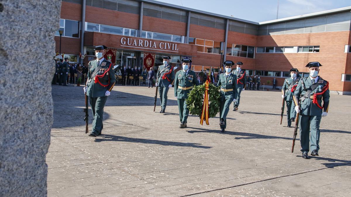 Dos guardias civiles portan la corona que rinde homenaje a sus compañeros caídos.