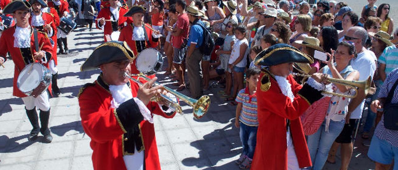 Numeroso público contempla el desfile de la banda de San Miguel por la avenida marítima.