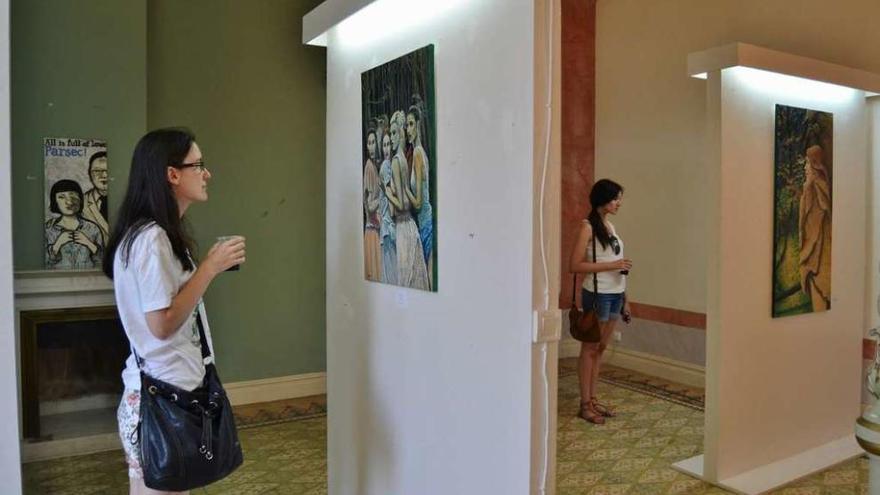 Dos chicas observan los cuadros del artista local Parsec!, en &quot;Soledad González&quot;.