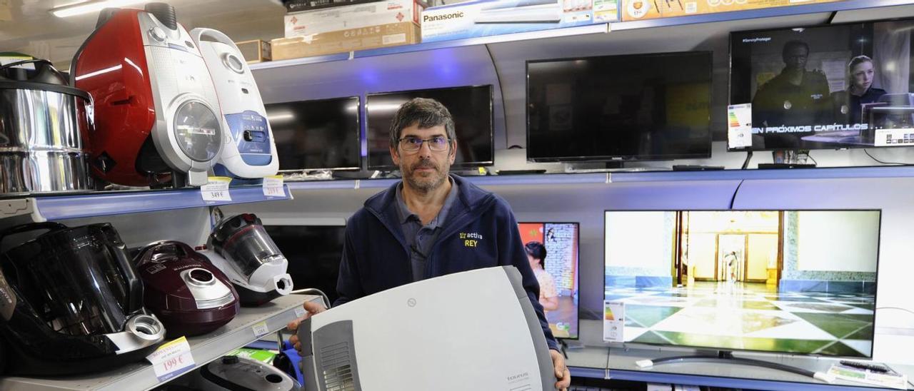 Uno de los empleados de la tienda de electrodomésticos Conecta Rey de A Estrada con alguno de sus productos .