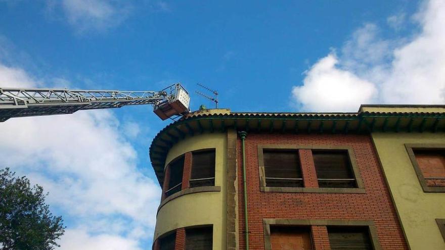 Los bomberos acceden al tejado con ayuda de una escalera telescópica.