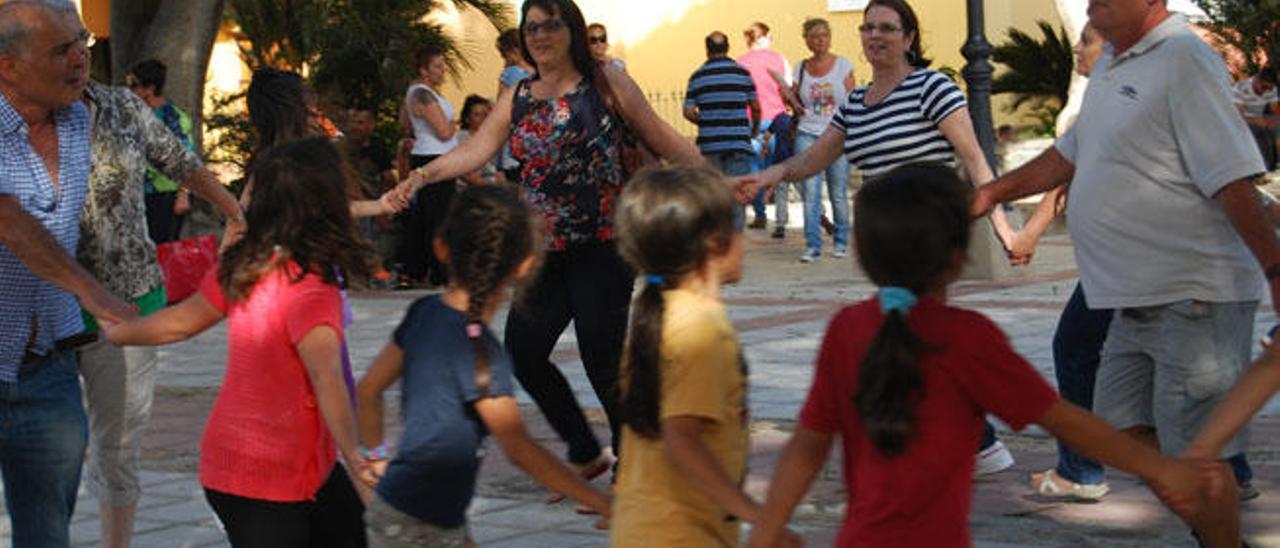 Un grupo de niños y mayores del proyecto &#039;De la casa a la plaza&#039; juegan en la plaza de Sardina del Sur.