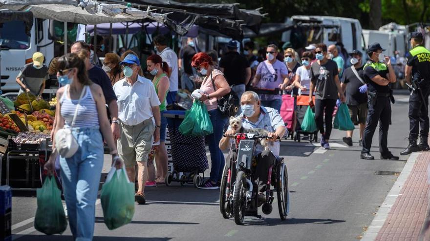 Varias personas en un mercadillo en Alcalá de Henares.