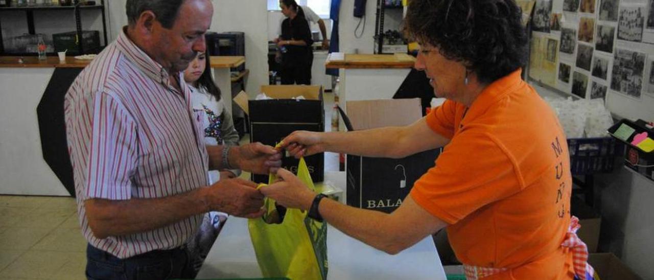 Sonia Rodríguez entrega el bollo a Nicancor Menéndez, en Muñó.