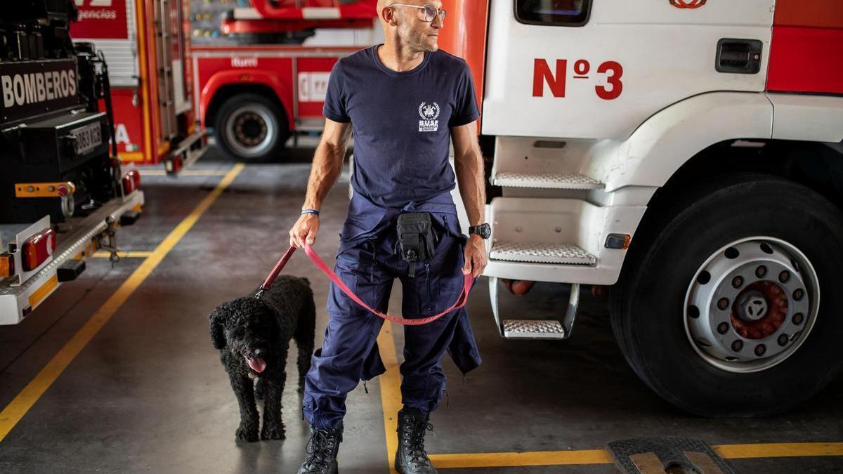 Un bombero de la comitiva que viajará a Marruecos, junto a Otto, el perro especializado en búsqueda de personas.