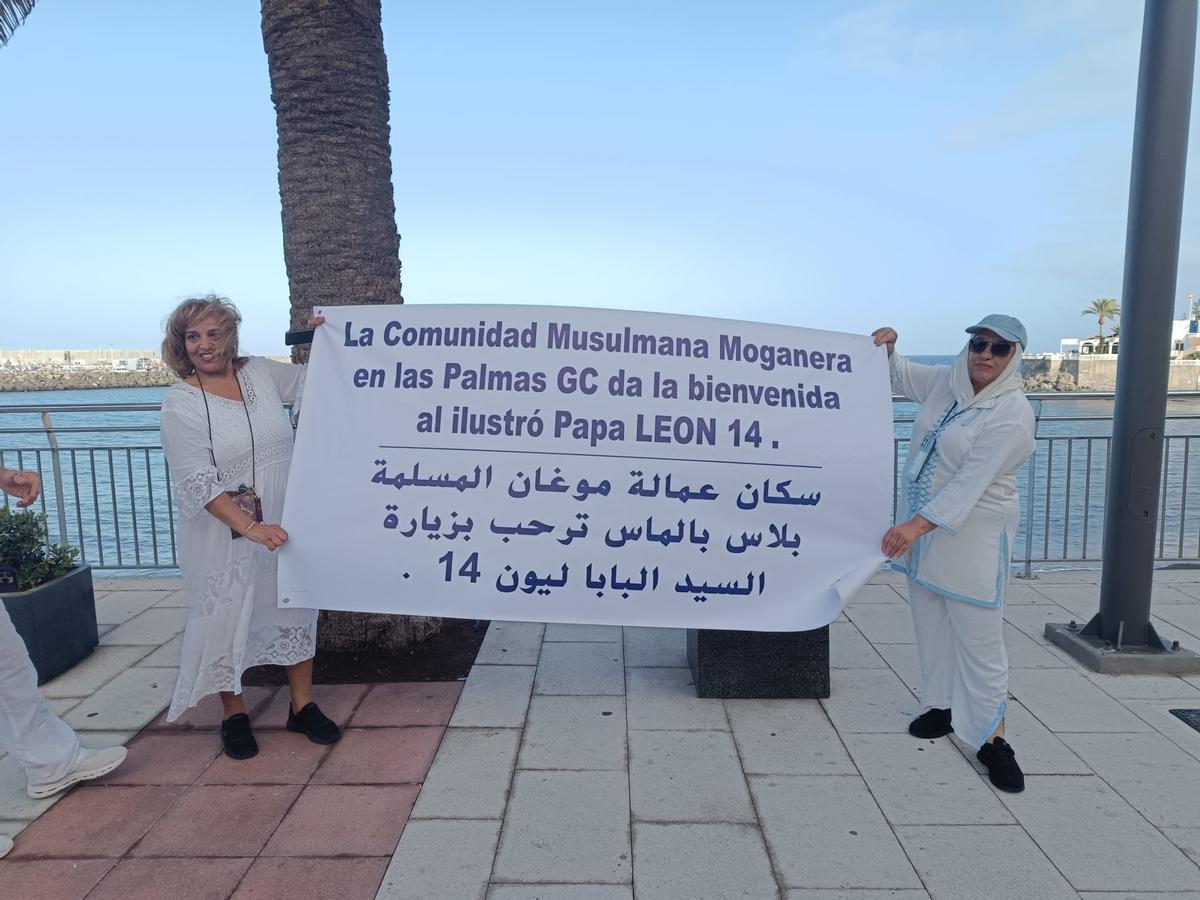Las integrantes de la comunidad musulmana moganera, Nadia Monsif y Rasida Thelmen, con un cartel para recibir al papa.