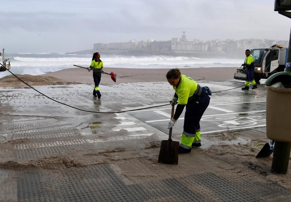 El mar empuja arena al paseo, cortado al tráfico