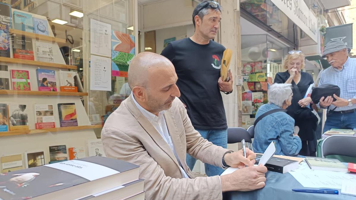 El escritor Jaume Oliver firma uno de sus libros al lector Fernando Arias