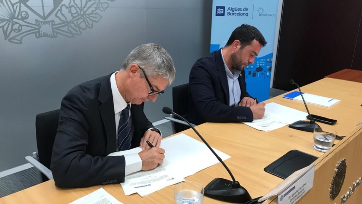 El director de Aguas de Barcelona, Ignacio Escudero, y el alcalde de Badalona, Àlex Pastor, firmando el convenio.