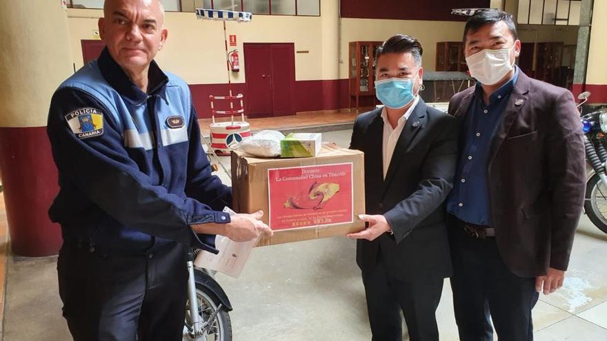 Los representantes de dos asociaciones chinas de Santa Cruz entregan mascarillas a la Policía Local.
