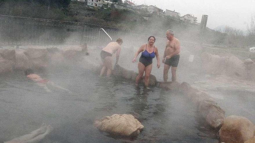 Un grupo de bañistas, ayer, en A Chavasqueira, donde el agua termal para el baño está a 43º. // Iñáki Osorio