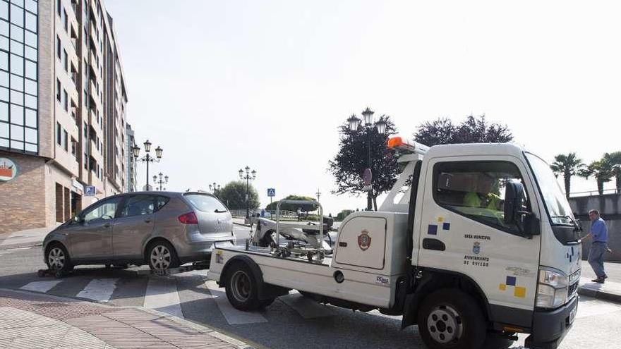 La grúa arrastra un coche hasta el depósito municipal de vehículos.