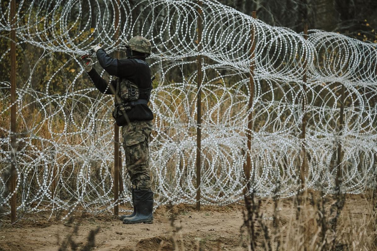 Soldados del ejército polaco arreglan bobinas de alambre de púas en una valla a lo largo de la frontera polaca, con el enclave ruso de Kaliningrado, cerca de Zerdziny, Polonia