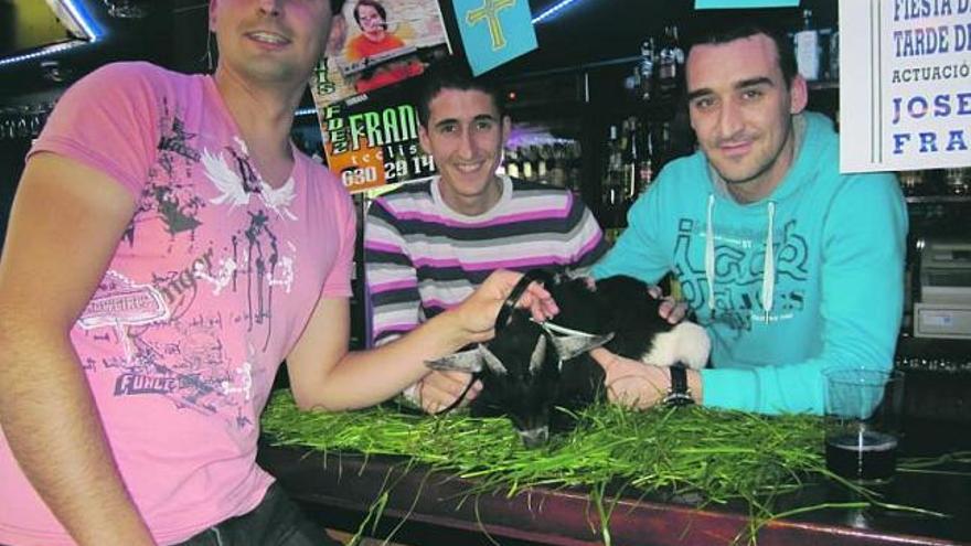El ganador de la cabra, Miguel Álvarez, y los hermanos Víctor y Roberto Álvarez, en una fiesta de prao moscona.