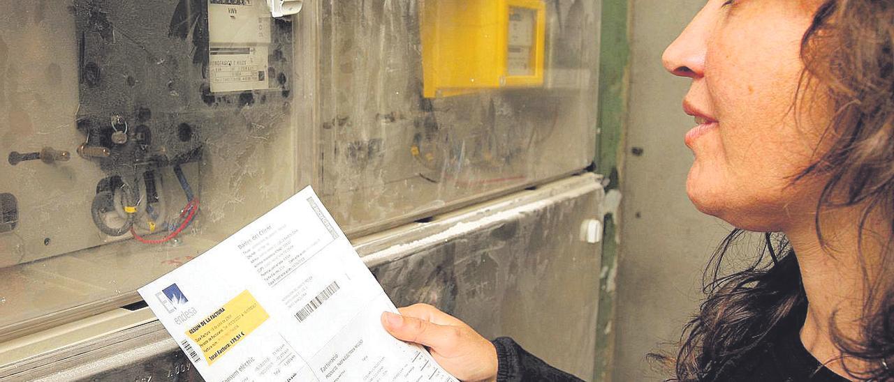 Una mujer mira la factura de la luz, preocupada por el incremento de gasto que encadena.