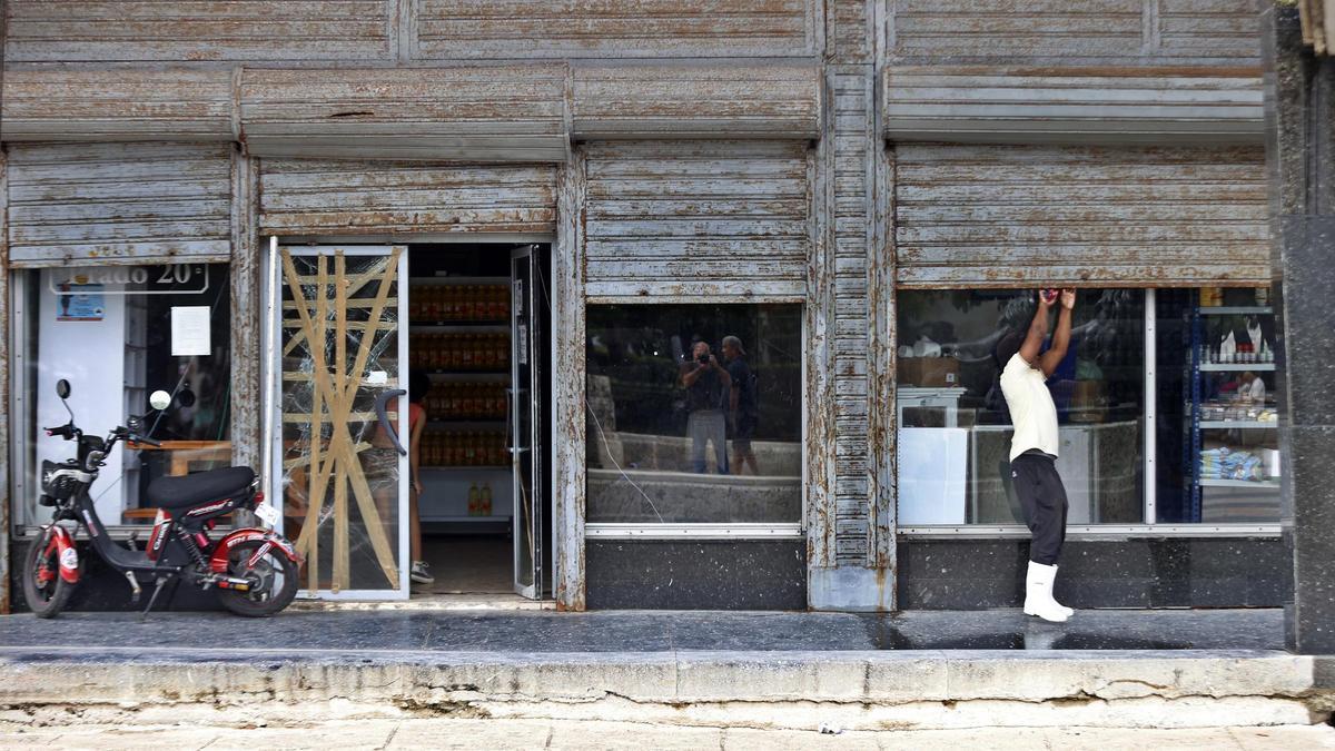 Un hombre cierra un local por falta de electricidad en La Habana, el viernes.