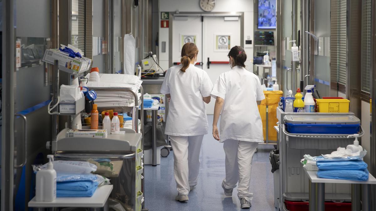 Dos profesionales sanitarios caminan en los pasillos de un hospital de Barcelona Dos profesionales sanitarios caminan en los pasillos de un hospital de Barcelona