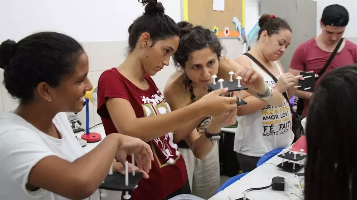 La profesora Mirella Di Lorenzo, en el centro, muestra a los estudiantes cómo construir las celdas de combustible microbianas del suelo.