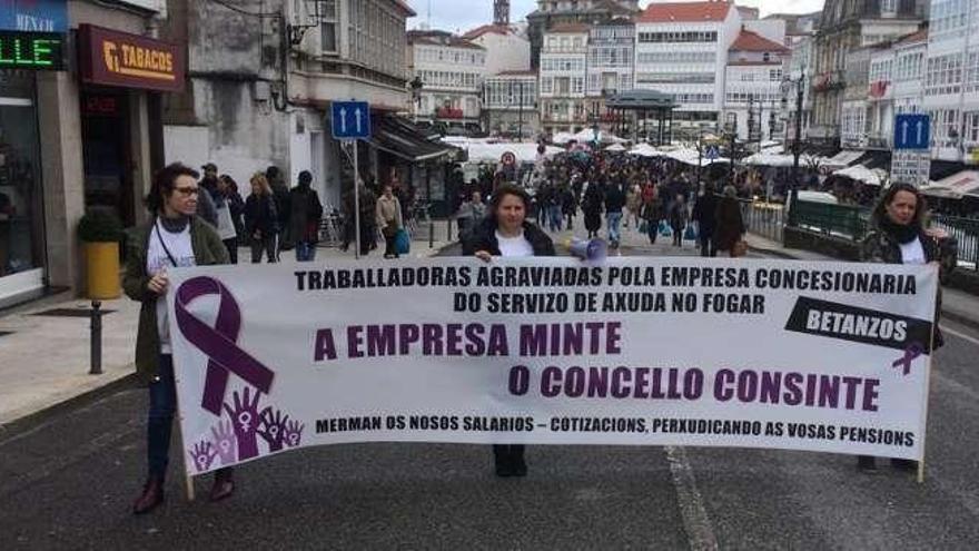 Tres de las empleadas durante la protesta de ayer en Betanzos