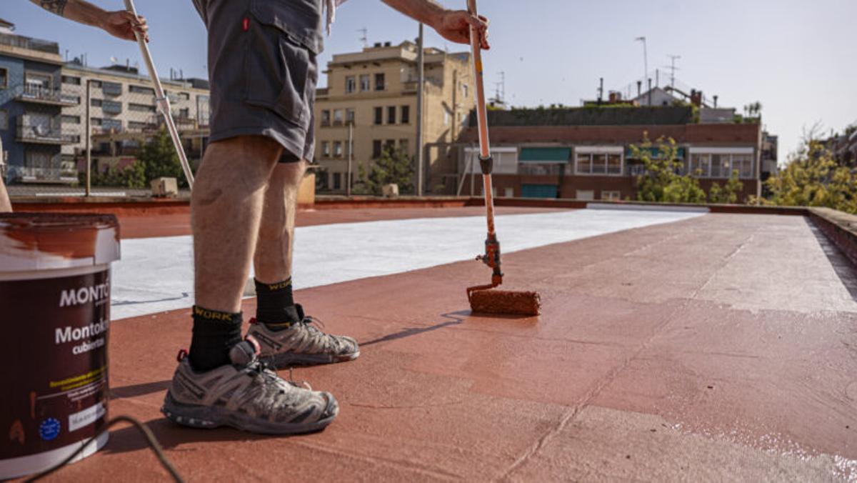 Un pintor aplica las diversas coberturas en el techo del Institut Escola Tres Fonts