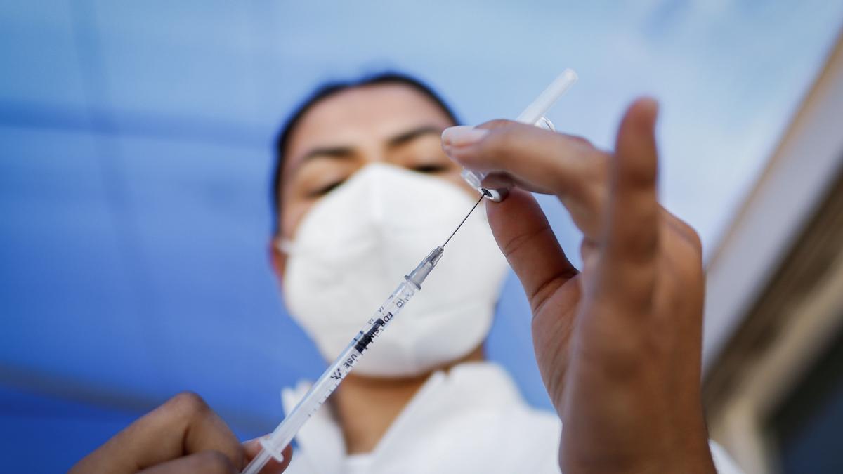 Una mujer sanitaria prepara una vacuna contra el COVID.