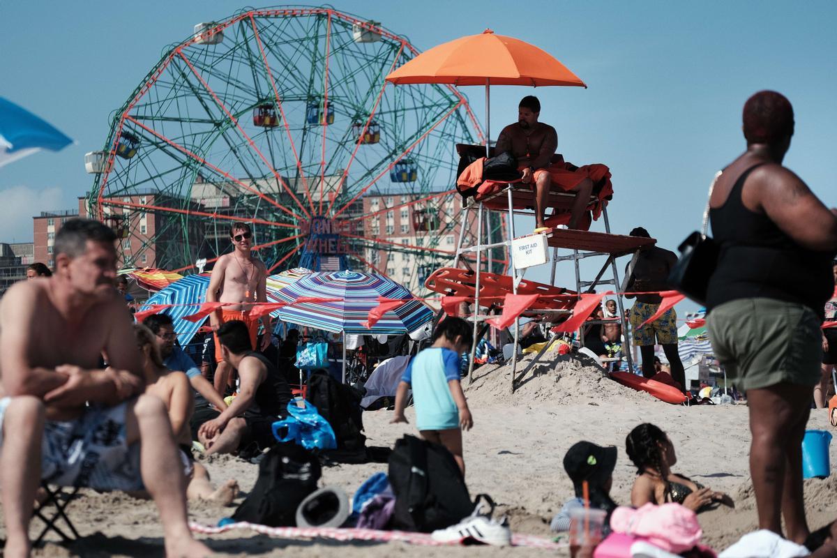 Un grupo de gente se refresca en la playa de Coney Island, en Brooklyn, en uno de los días más calurosos del año, en Nueva York.