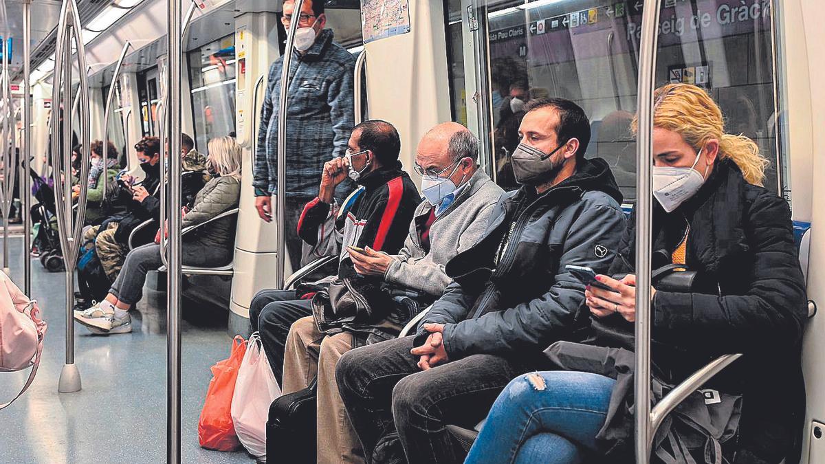 Viajeros de metro con mascarilla.