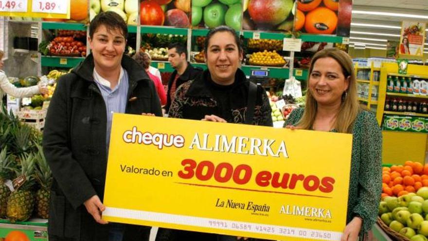 Pilar Alonso Zaballos, de Oviedo, en el centro, recoge su cheque de 3.000 euros en compras de manos de la supervisora del Alimerka Ana Belén Velasco (a la izquierda) y de Belén Bobes, de LA NUEVA ESPAÑA. | pablo solares