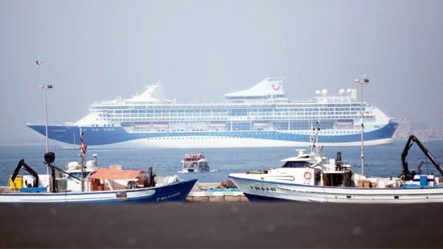 El creuer al fons amb un vaixell llançadora transportant passatgers i en primer terme el port.