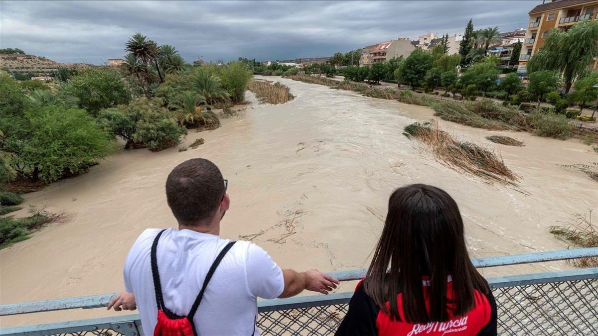 Dos chicos observan la crecida del rio Segura tras desbordarse por las dos margenes a su paso por Archena  Murcia