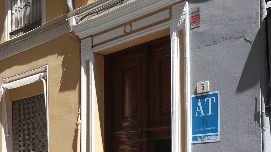 Jóvenes en la entrada de un apartamento turístico en el Centro de Málaga.