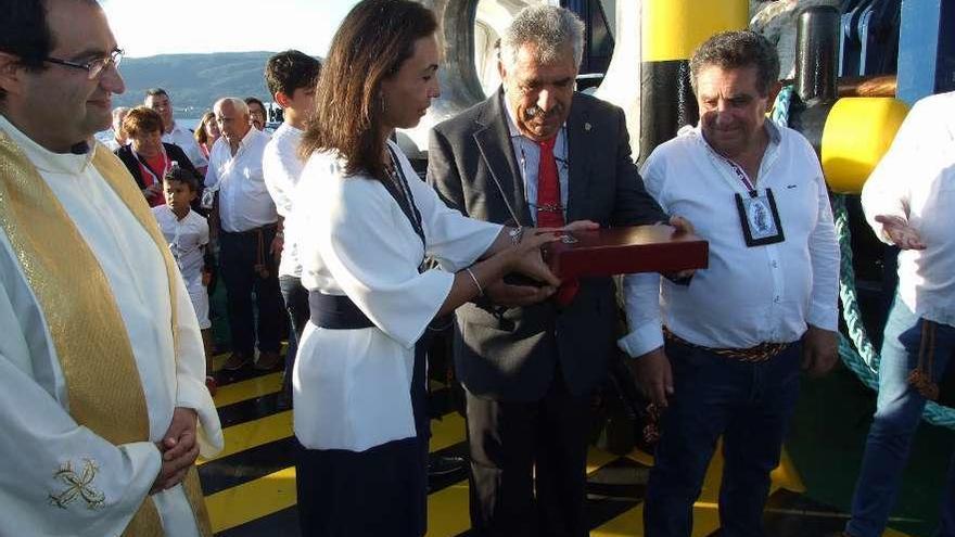 La alcaldesa entrega un recuerdo al Antonio Alonso, de Amare Marín, que se presta todos los años a portar la imagen de la Virgen en sus remolcadores. // Santos Álvarez