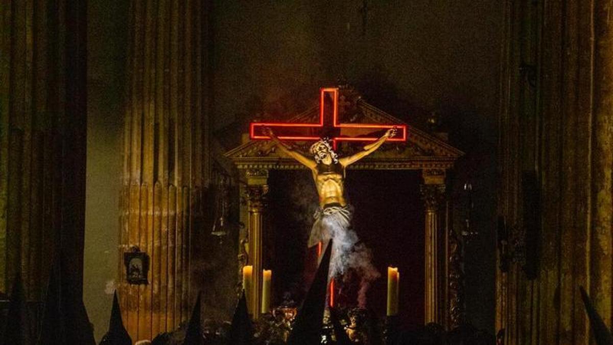La cruz encarnada destaca en la oscuridad en la imagne del Cristo del Silencio
