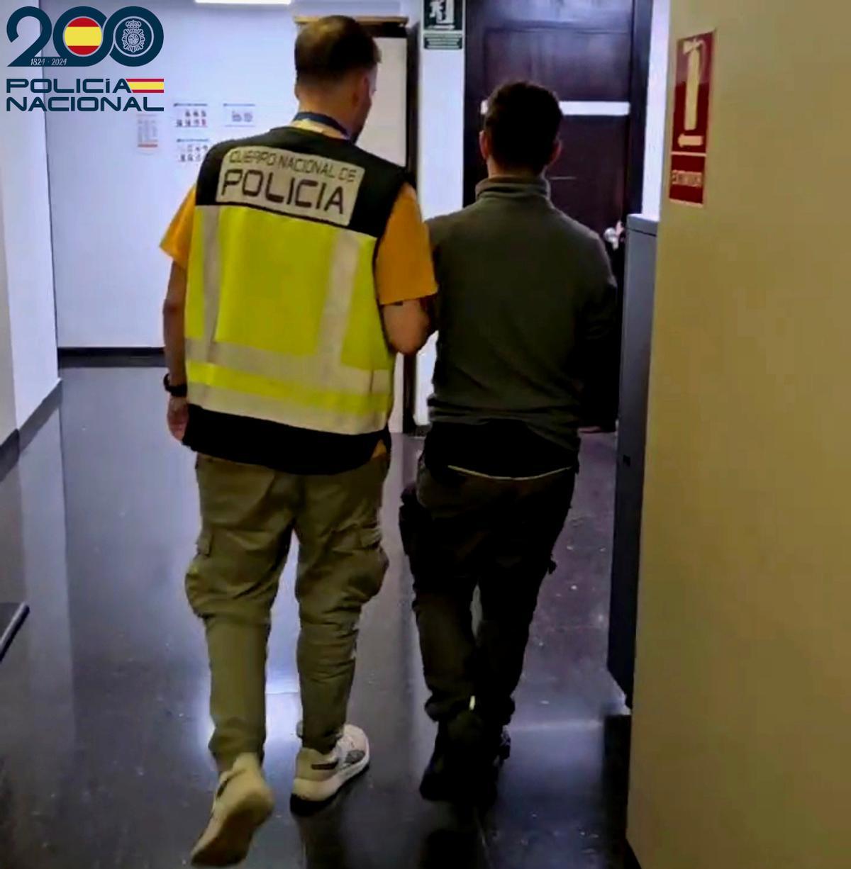 Un policía nacional con uno de los jóvenes detenidos