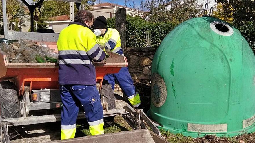 Dos trabajadores de Torregamones depositan botellas en un contenedor para su posterior reciclado. | Cedida