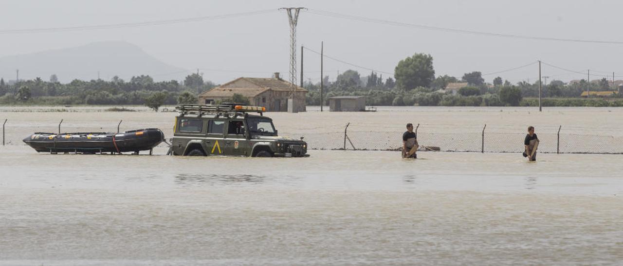 Militares atravesando una zona de huerta del municipio de Daya Vieja, completamente bajo las aguas del río Segura tras volver a tener desbordamientos por las brechas en el cauce.