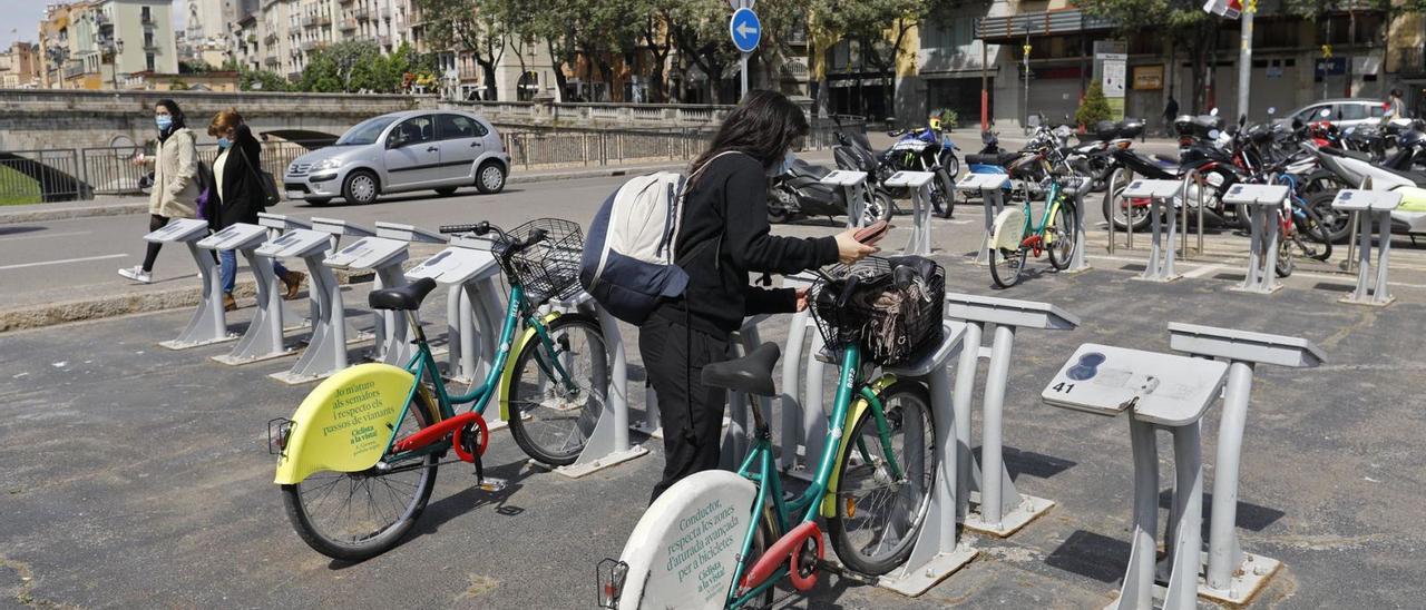 Una dona utilitza una bicicleta del servei públic de Girona. | ANIOL RESCLOSA