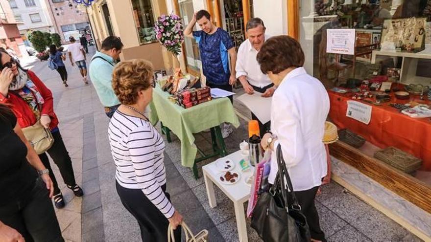 Varias personas degustan productos del comercio justo en un estand.