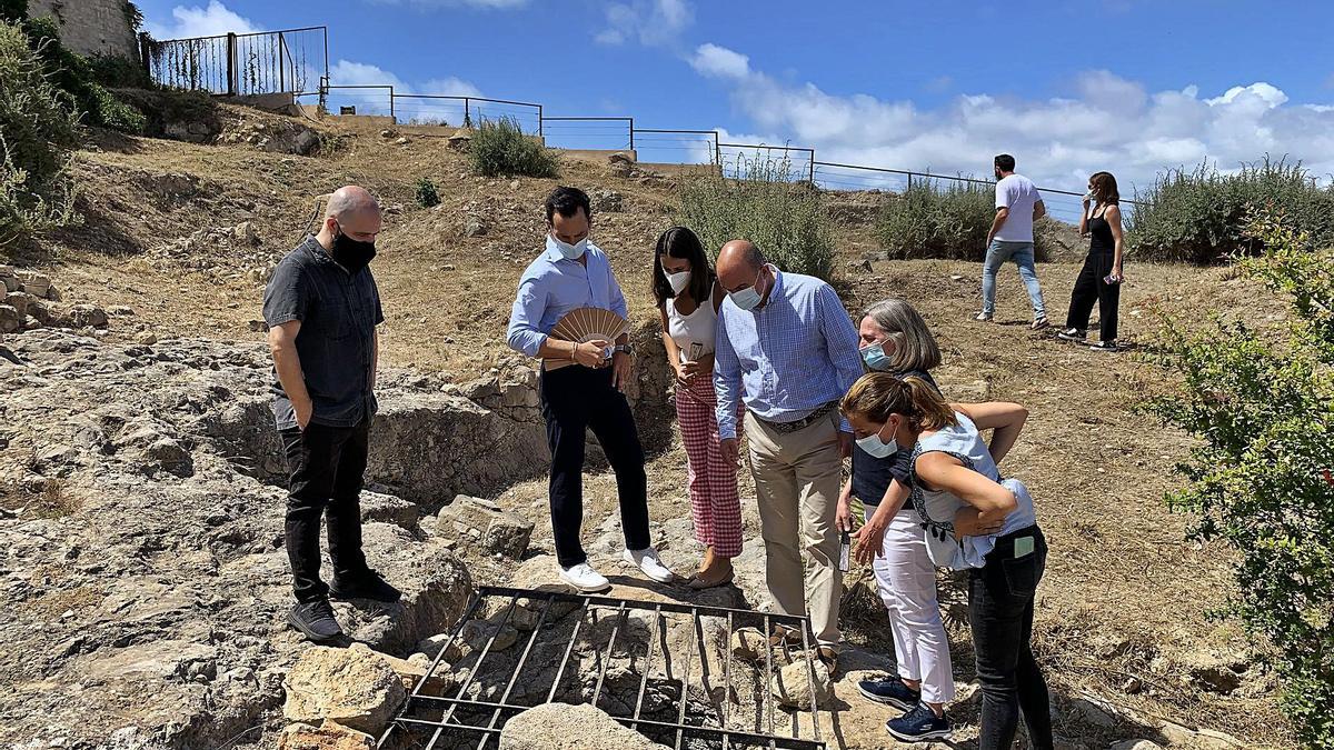 Gurrea muestra a los políticos uno de los restos en la zona del solar en la que ya se ha excavado.