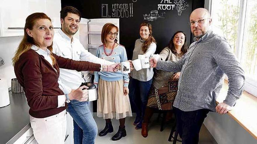 Usuarios de The Roof, con sus tazas personalizadas, brindan en la cocina del &#039;coworking&#039; de Juan Flórez