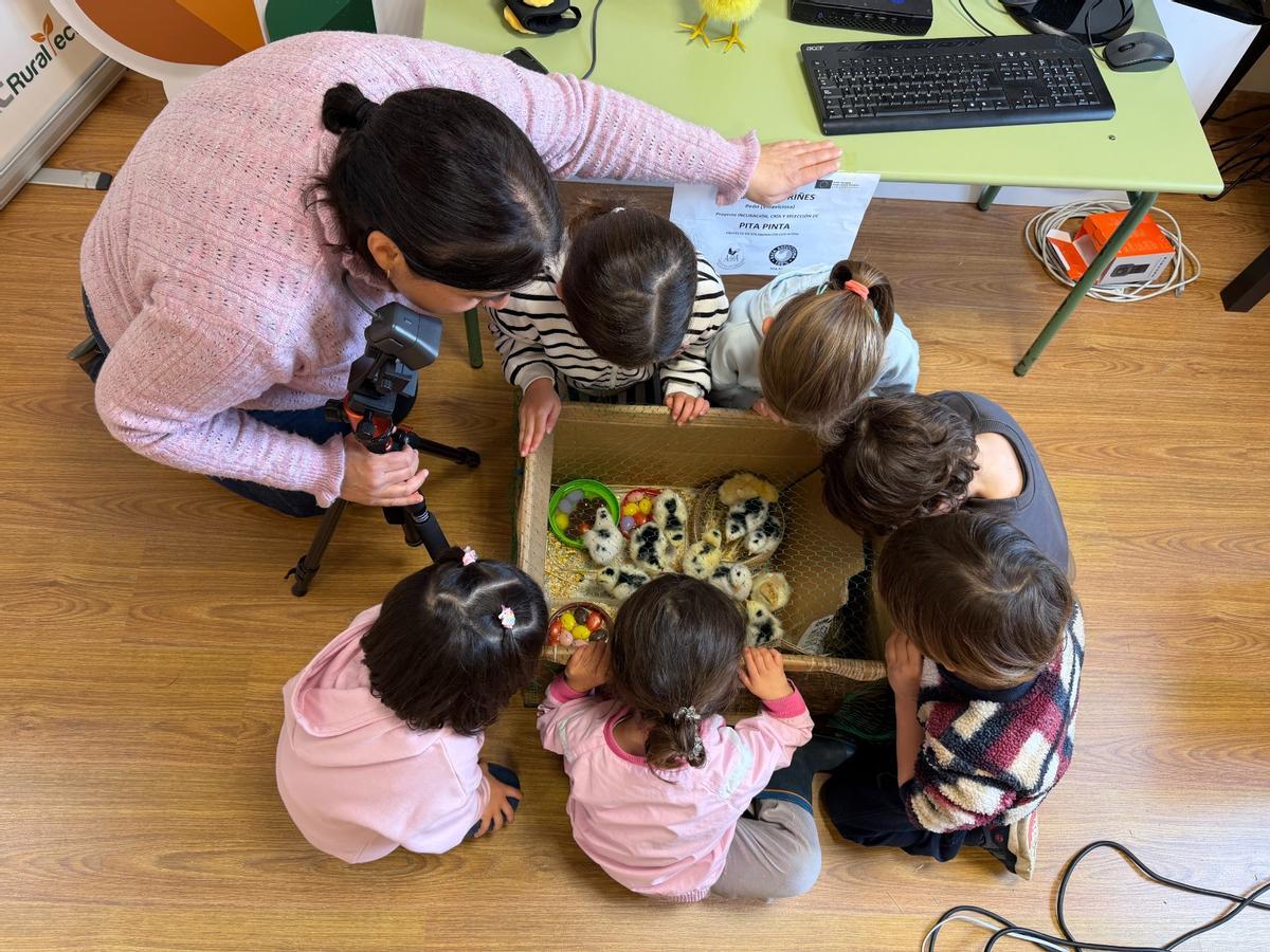 La profesora Marta Ovies con los niños de Peón y los pitinos recién nacidos.