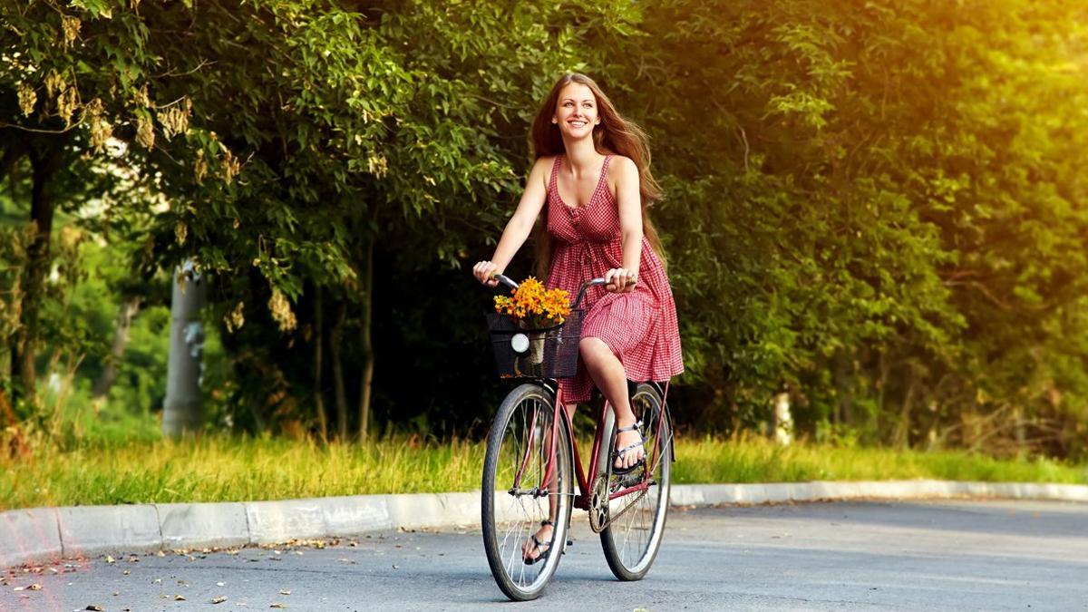 Una mujer pasea en bicicleta por el campo