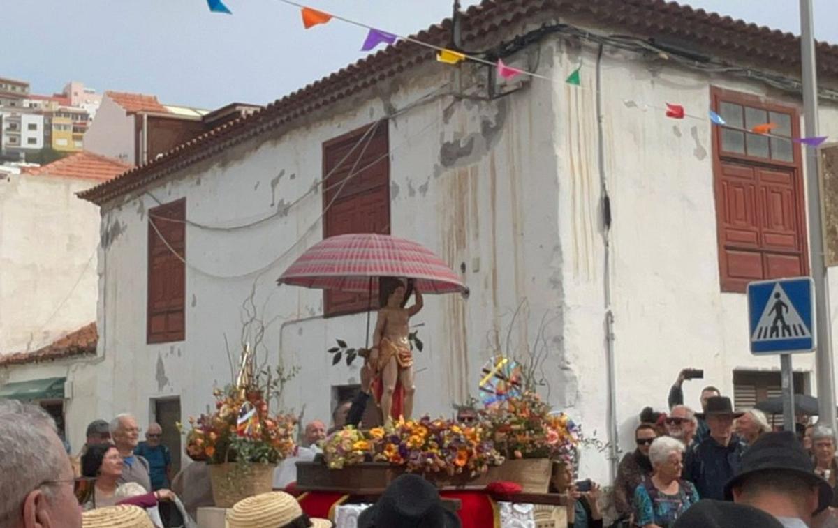 El santo, bajo la protección de un paraguas en un  momento del paseo.   | EL DÍA