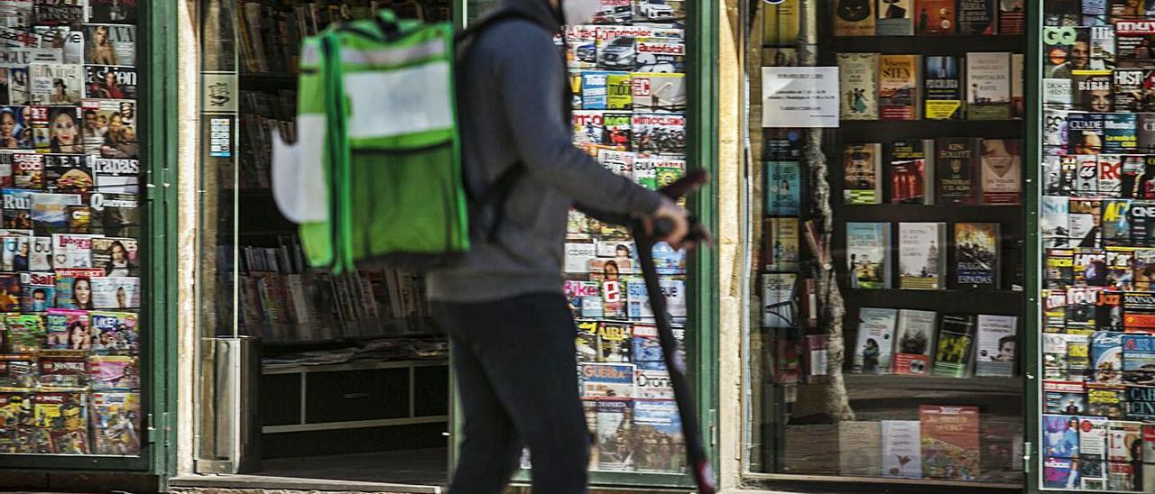 Un repartidor pasa en patinete eléctrico por la plaza de Riego. | Irma Collín