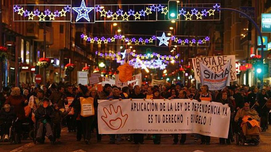 La cabecera de la manifestación a su paso por la céntrica avenida de Maisonnave, en Alicante, engalanada con motivo de las fiestas navideñas