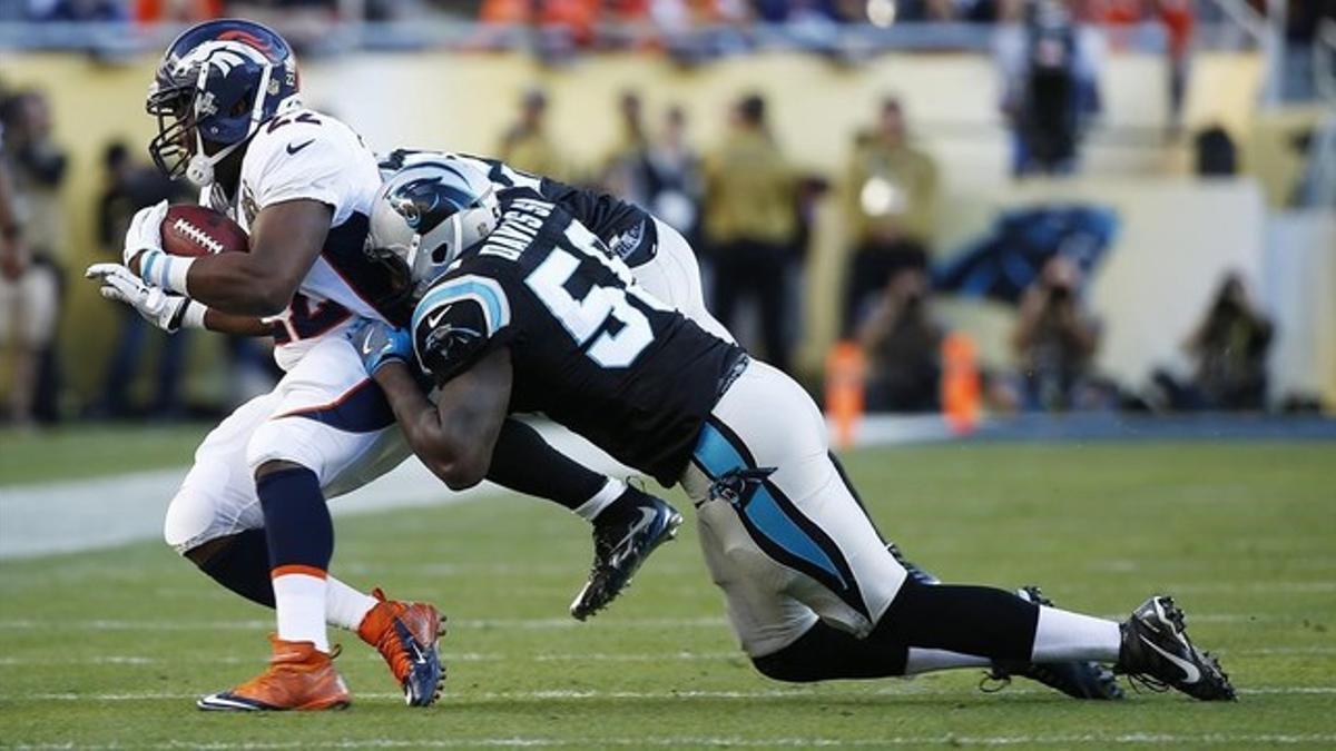 El running back de los Broncos J. Anderson, interceptado por Thomas Davis de los Carolina Panthers.