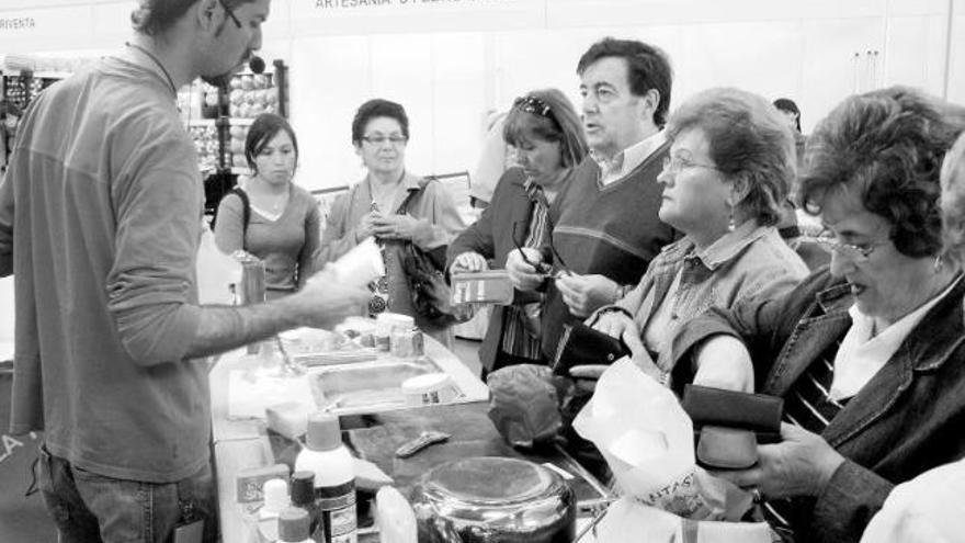 Compradores, ayer, en uno de los puestos de la feria veigueña.