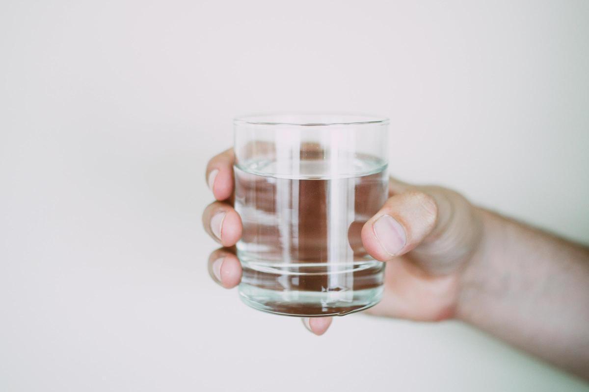 Una persona sostiene un vaso de agua