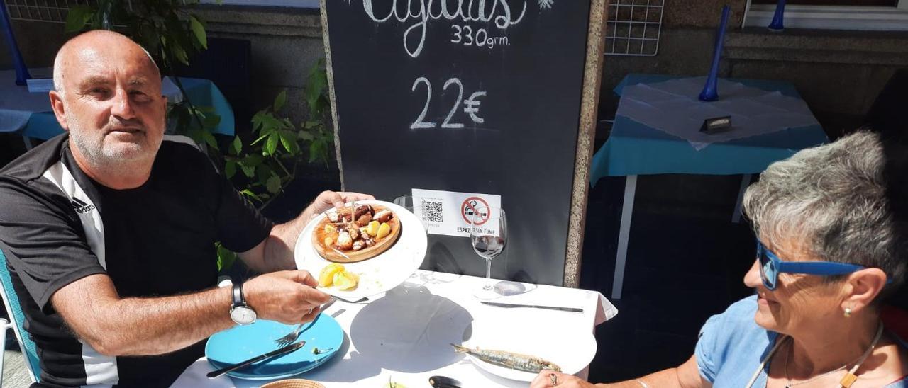 Dos turistas consumen una tapa de pulpo “á feira” en el restaurante Herlogón de O Grove, ayer.   | //  FDV